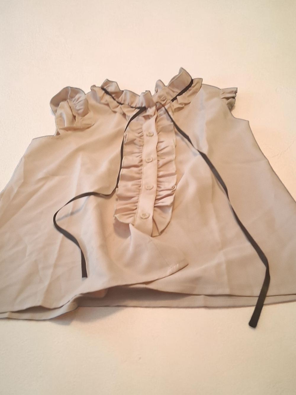 woman's beige sleeveless blouse featuring ruffled front decorative black ribbon - Picture 3 of 5